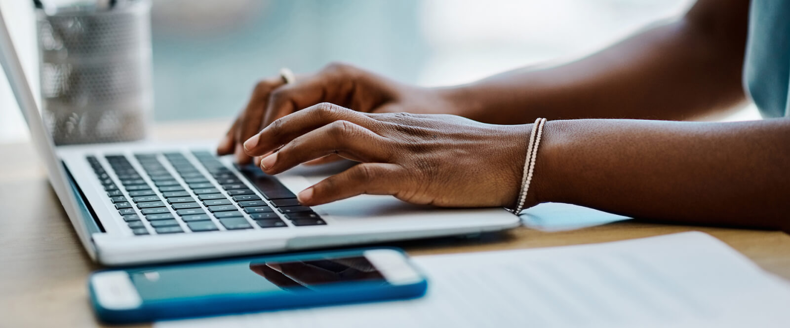 Close-up of hands typing on a laptop keyboard