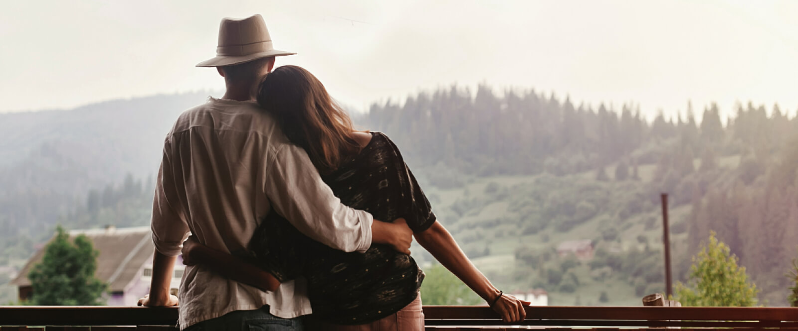 Young couple embracing while looking out at a mountain